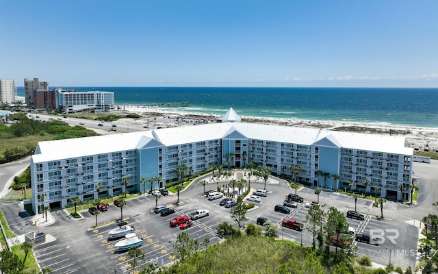 birds eye view of property with a water view and a beach view