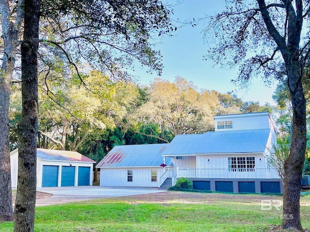 view of front of home with a garage, a front lawn, and an outdoor structure