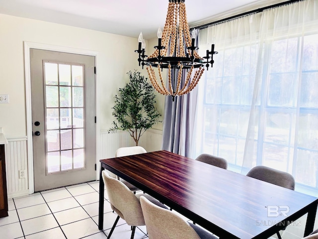 tiled dining room with an inviting chandelier