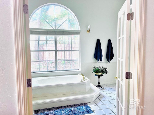 bathroom featuring tile patterned flooring and a tub to relax in