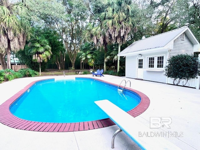 view of pool featuring a diving board and a patio area