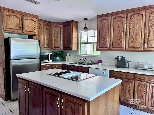 kitchen with sink, hanging light fixtures, stainless steel appliances, light tile patterned floors, and a kitchen island