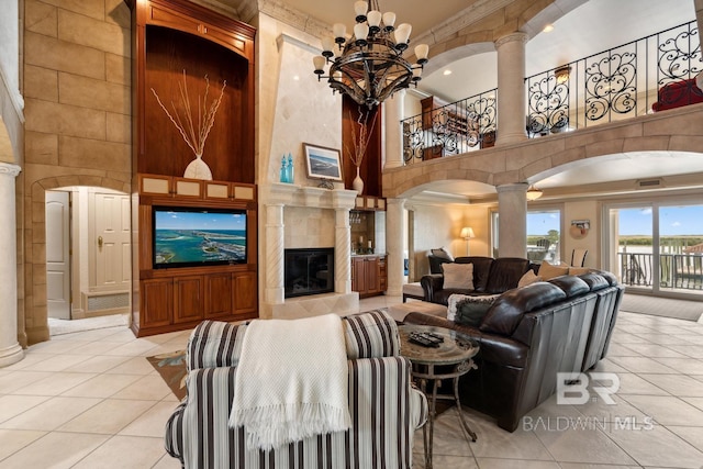 28452 Ono Blvd, Orange Beach, AL 36561 - living room featuring decorative columns, a towering ceiling, tile patterned flooring, crown molding, and arched walkways
