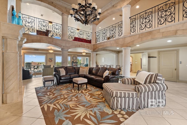 28452 Ono Blvd, Orange Beach, AL 36561 - living room featuring ornate columns, tile patterned floors, a towering ceiling, ornamental molding, and a chandelier