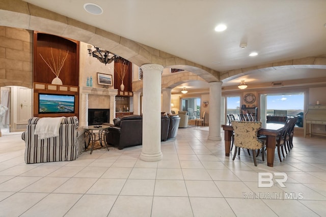 28452 Ono Blvd, Orange Beach, AL 36561 - dining room featuring decorative columns, tile patterned flooring, a high end fireplace, recessed lighting, and arched walkways