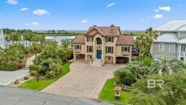 28452 Ono Blvd, Orange Beach, AL 36561 - mediterranean / spanish home featuring a tile roof, a chimney, stucco siding, driveway, and a garage