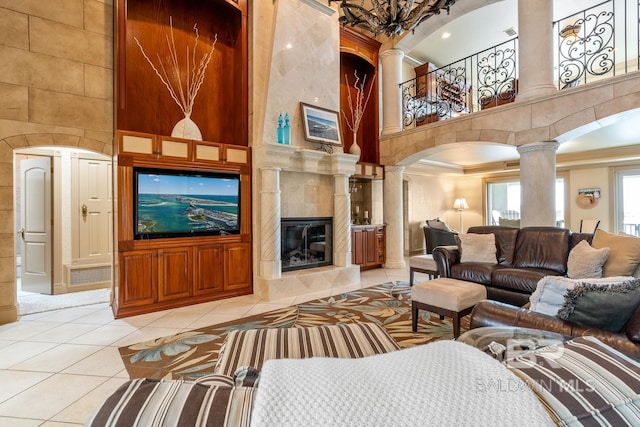 28452 Ono Blvd, Orange Beach, AL 36561 - living room with decorative columns, a towering ceiling, crown molding, light tile patterned flooring, and arched walkways