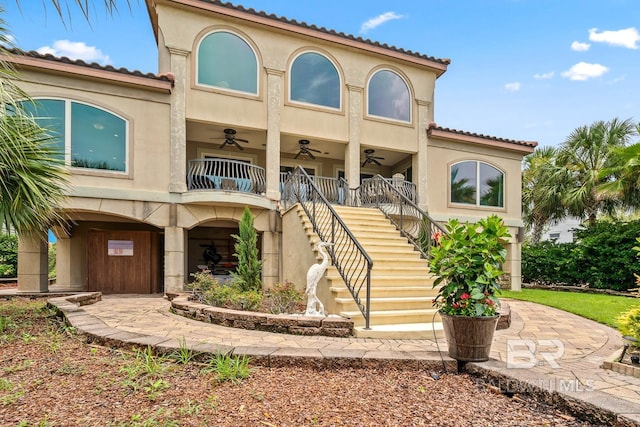 28452 Ono Blvd, Orange Beach, AL 36561 - view of front of home featuring ceiling fan, stairway, stucco siding, and a tiled roof