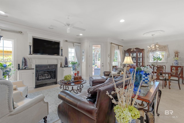living area featuring a high end fireplace, ornamental molding, ceiling fan with notable chandelier, and recessed lighting