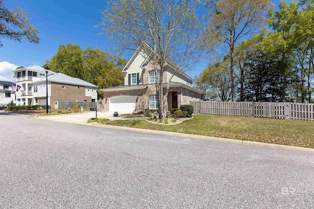 traditional-style home featuring stone siding, fence, concrete driveway, and a front yard