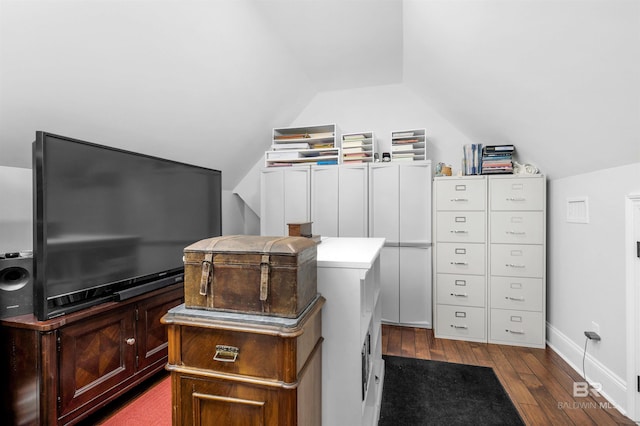 interior space with dark wood-style floors, lofted ceiling, and baseboards