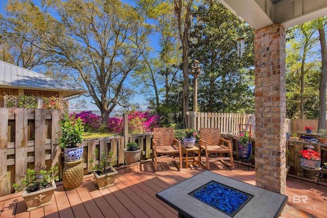 deck featuring an outdoor fire pit and fence