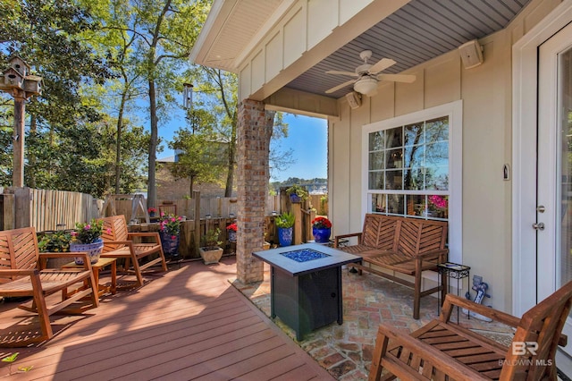 wooden deck featuring a fire pit, ceiling fan, and fence