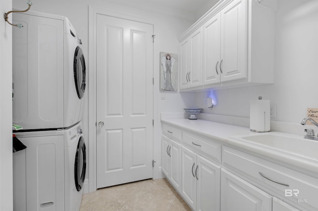 clothes washing area featuring a sink, cabinet space, stacked washer / dryer, and light tile patterned floors