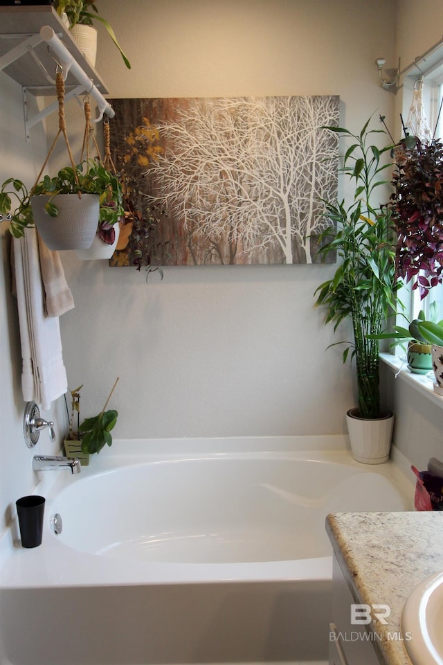 bathroom with vanity, a bathtub, and plenty of natural light