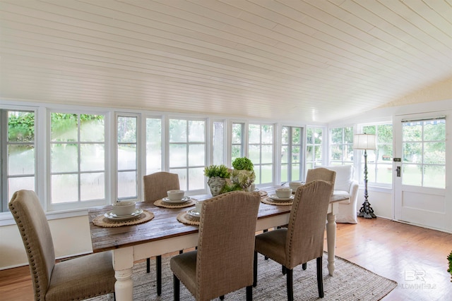 dining space featuring lofted ceiling and light wood-type flooring