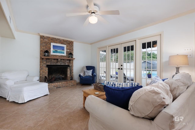 tiled living room featuring ceiling fan, french doors, ornamental molding, and a brick fireplace