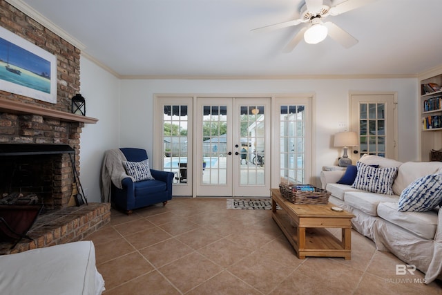 living room featuring french doors, a brick fireplace, ornamental molding, ceiling fan, and light tile patterned floors