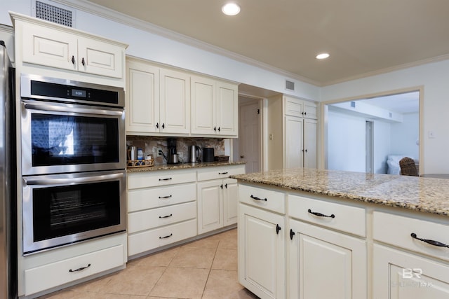 kitchen featuring decorative backsplash, light stone countertops, ornamental molding, light tile patterned flooring, and stainless steel double oven