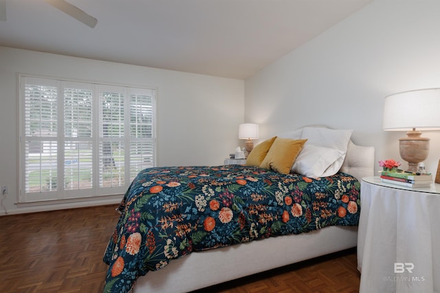 bedroom featuring ceiling fan, dark parquet floors, and multiple windows