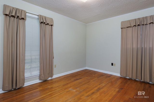 unfurnished room with a textured ceiling and wood-type flooring