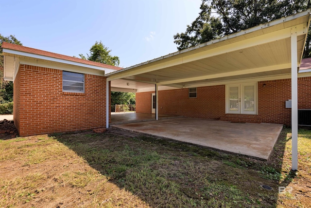 back of house featuring a lawn and a carport