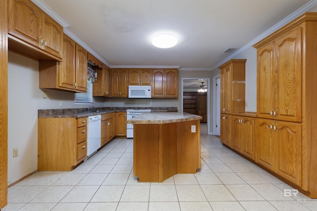 kitchen with light tile patterned floors, sink, white appliances, and a kitchen island