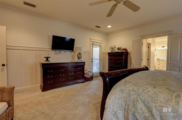 carpeted bedroom with visible vents, crown molding, and a decorative wall