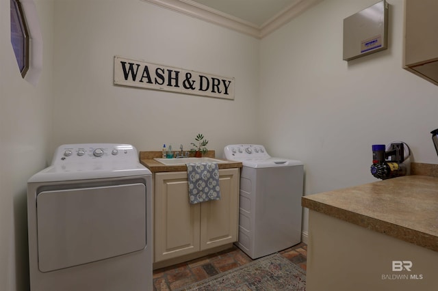 clothes washing area with a sink, cabinet space, independent washer and dryer, and crown molding