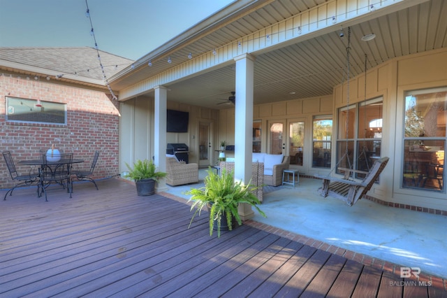 wooden deck featuring area for grilling, outdoor dining area, and a ceiling fan