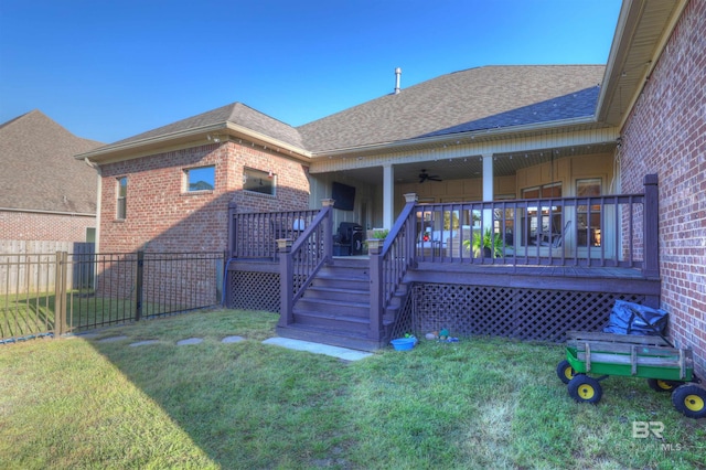 back of property featuring a yard, brick siding, a shingled roof, and fence