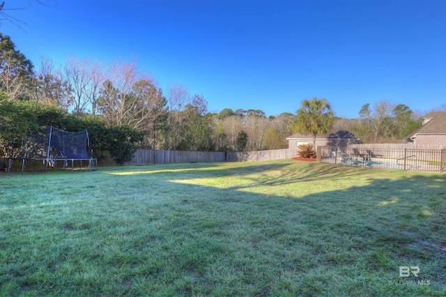 view of yard featuring a fenced backyard and a trampoline