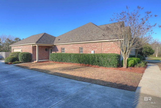 view of front of home featuring a garage, brick siding, and a shingled roof