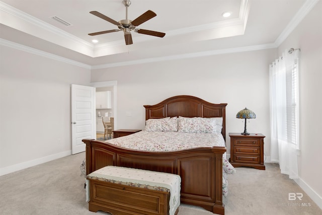 bedroom featuring light colored carpet, a tray ceiling, visible vents, and crown molding