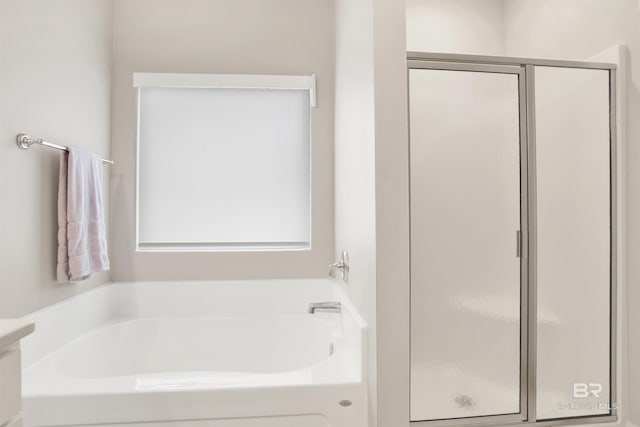 full bathroom featuring a garden tub and a shower stall