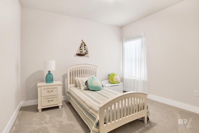 bedroom featuring light carpet and baseboards