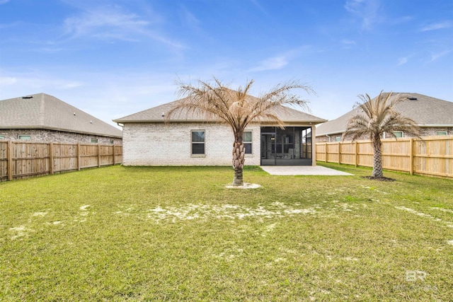 back of property with a lawn, a patio, a sunroom, a fenced backyard, and brick siding