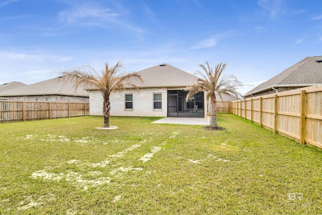 back of property with a yard, a patio, a fenced backyard, and a sunroom