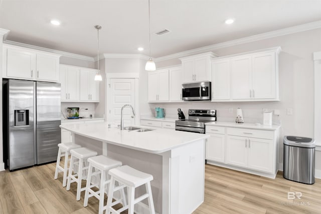 kitchen with visible vents, stainless steel appliances, a sink, and ornamental molding