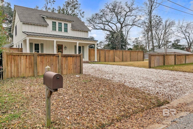 modern inspired farmhouse featuring metal roof, a shingled roof, fence, board and batten siding, and a standing seam roof