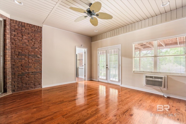 spare room featuring ceiling fan, wood ceiling, a wall mounted AC, french doors, and light wood-type flooring