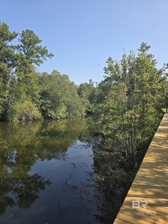 dock area with a water view and a forest view