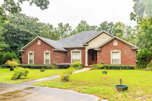 single story home with roof with shingles, a front lawn, and brick siding