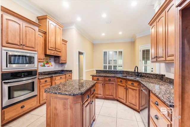 kitchen with ornamental molding, stainless steel appliances, a center island, and sink