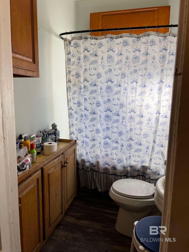 full bathroom with toilet, shower / tub combo, vanity, and hardwood / wood-style floors