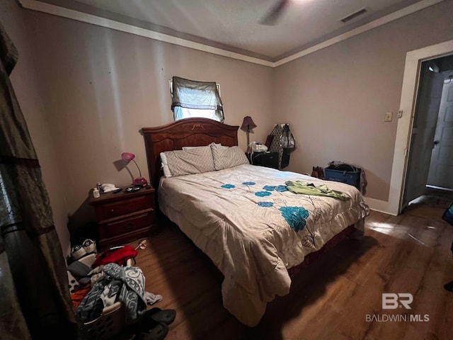 bedroom featuring ceiling fan, crown molding, and dark hardwood / wood-style floors