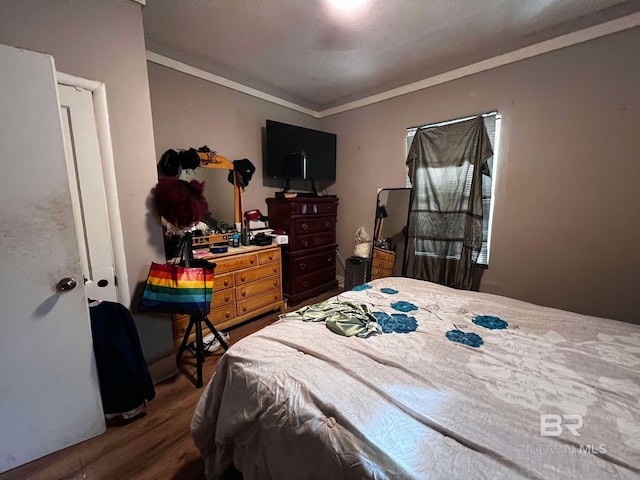 bedroom featuring hardwood / wood-style flooring and crown molding