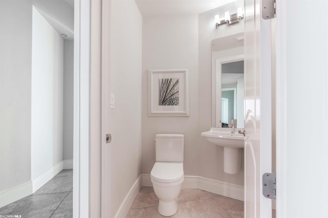 bathroom with toilet and tile floors