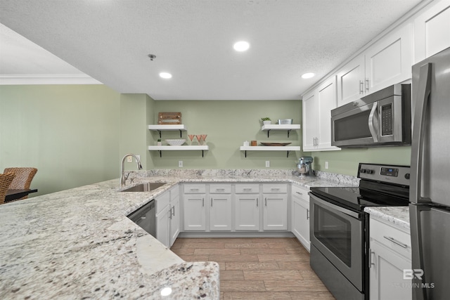 375 Beach Club Trl Unit B404, Gulf Shores, AL 36542 - kitchen featuring appliances with stainless steel finishes, open shelves, a sink, light wood-style floors, and crown molding