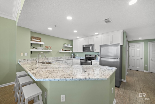 375 Beach Club Trl Unit B404, Gulf Shores, AL 36542 - kitchen featuring stainless steel appliances, a sink, open shelves, white cabinetry, and recessed lighting